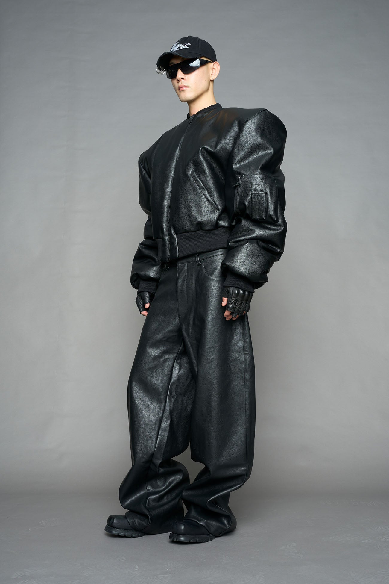 model wearing black vegan leather bomber jacket with large shoulders