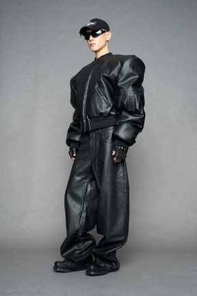 model wearing black vegan leather bomber jacket with large shoulders