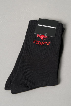 Black ribbed sport socks with red embroidered dragon and bold ‘KETAMINE’ slogan by Namilia, unisex mid-calf fit.