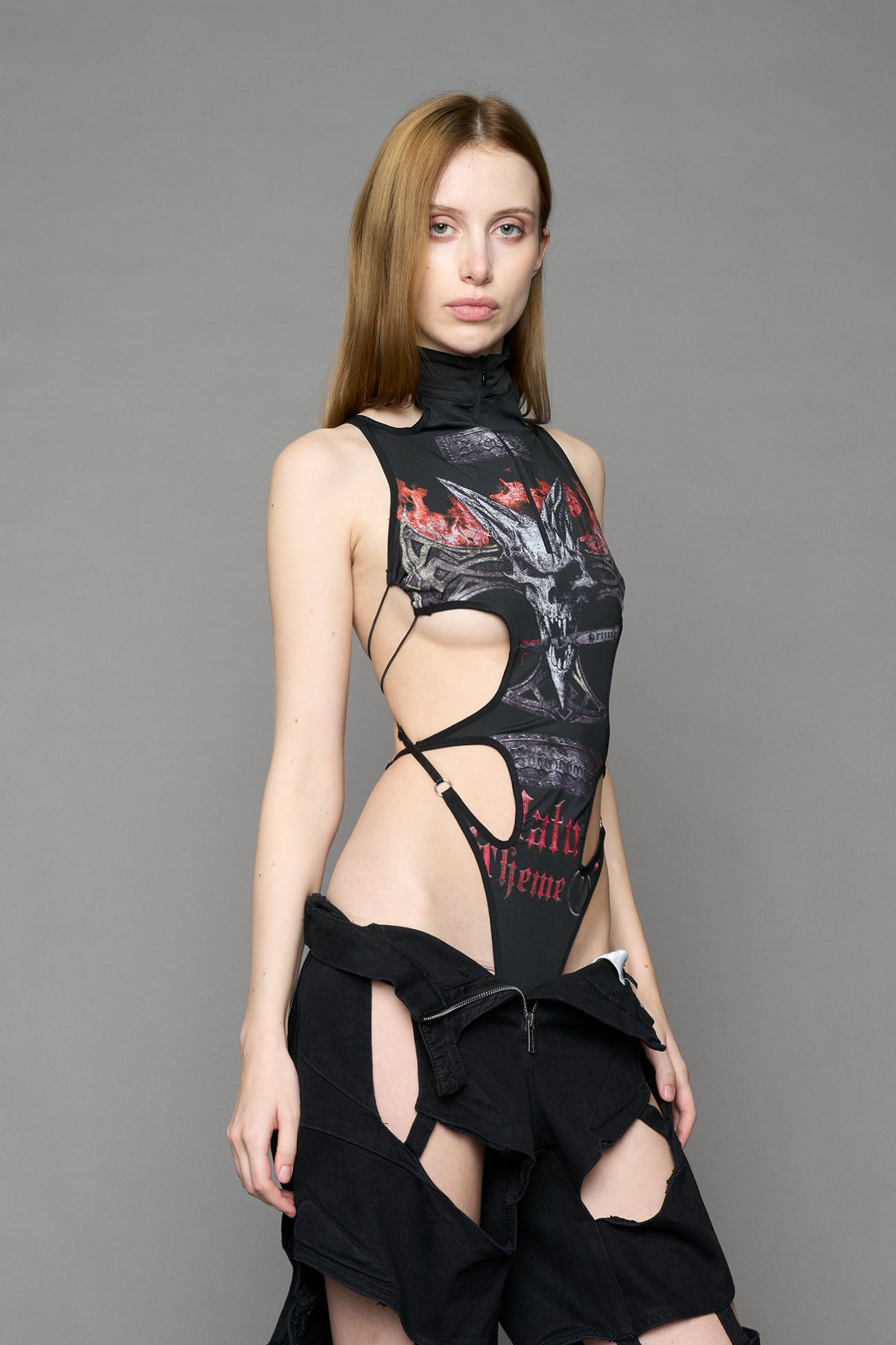 Black print cut-out bodysuit by NAMILIA with high neckline, front zip, adjustable straps, and metal ring detailing