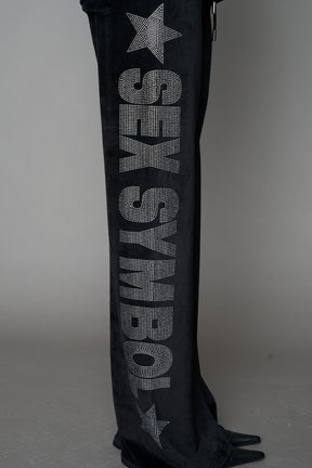 Black velour pants with NAMILIA x Symbol rhinestone detailing and a fitted straight-leg silhouette