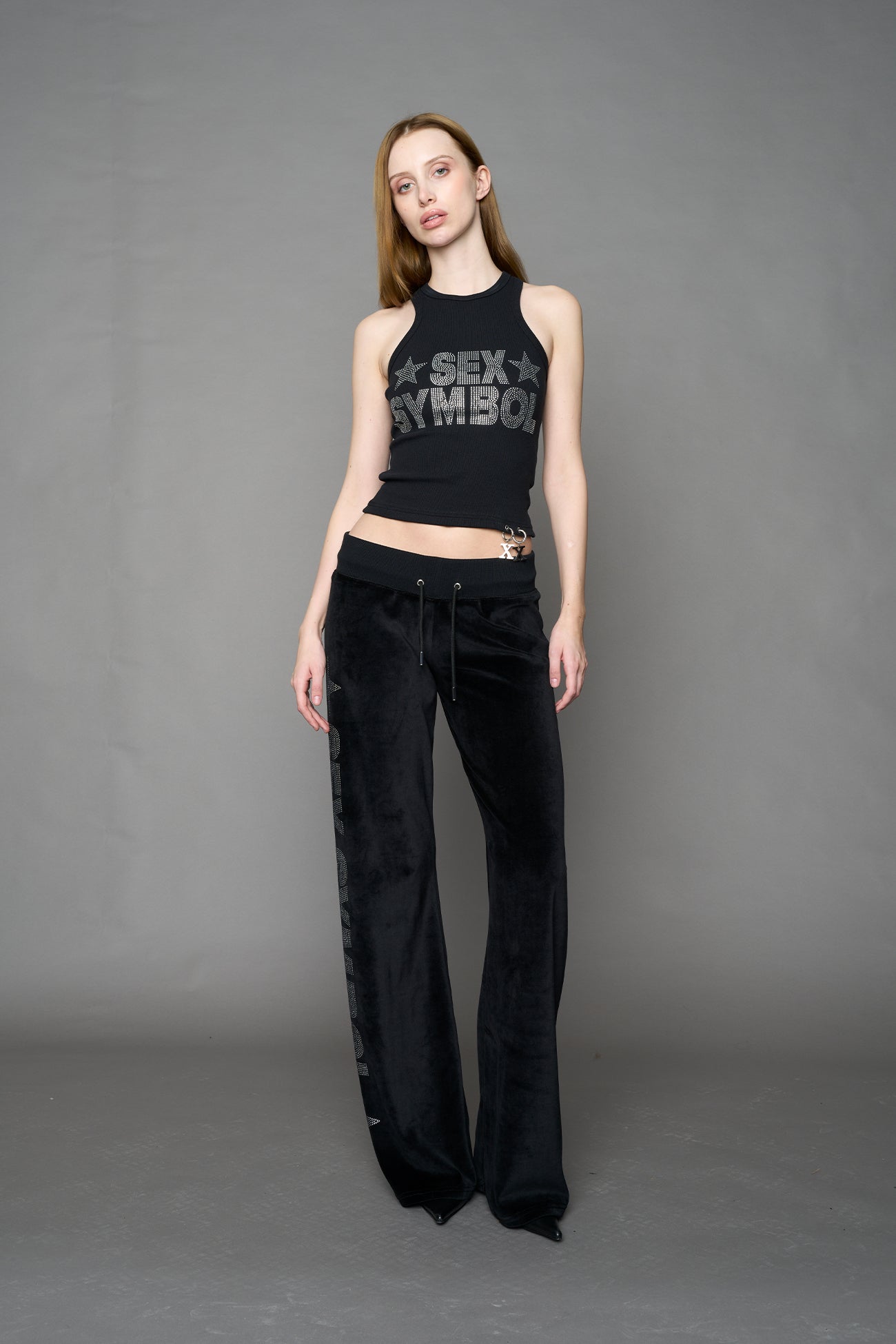 Black velour pants with NAMILIA x Symbol rhinestone detailing and a fitted straight-leg silhouette