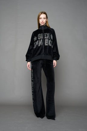 Black velour pants with NAMILIA x Symbol rhinestone detailing and a fitted straight-leg silhouette