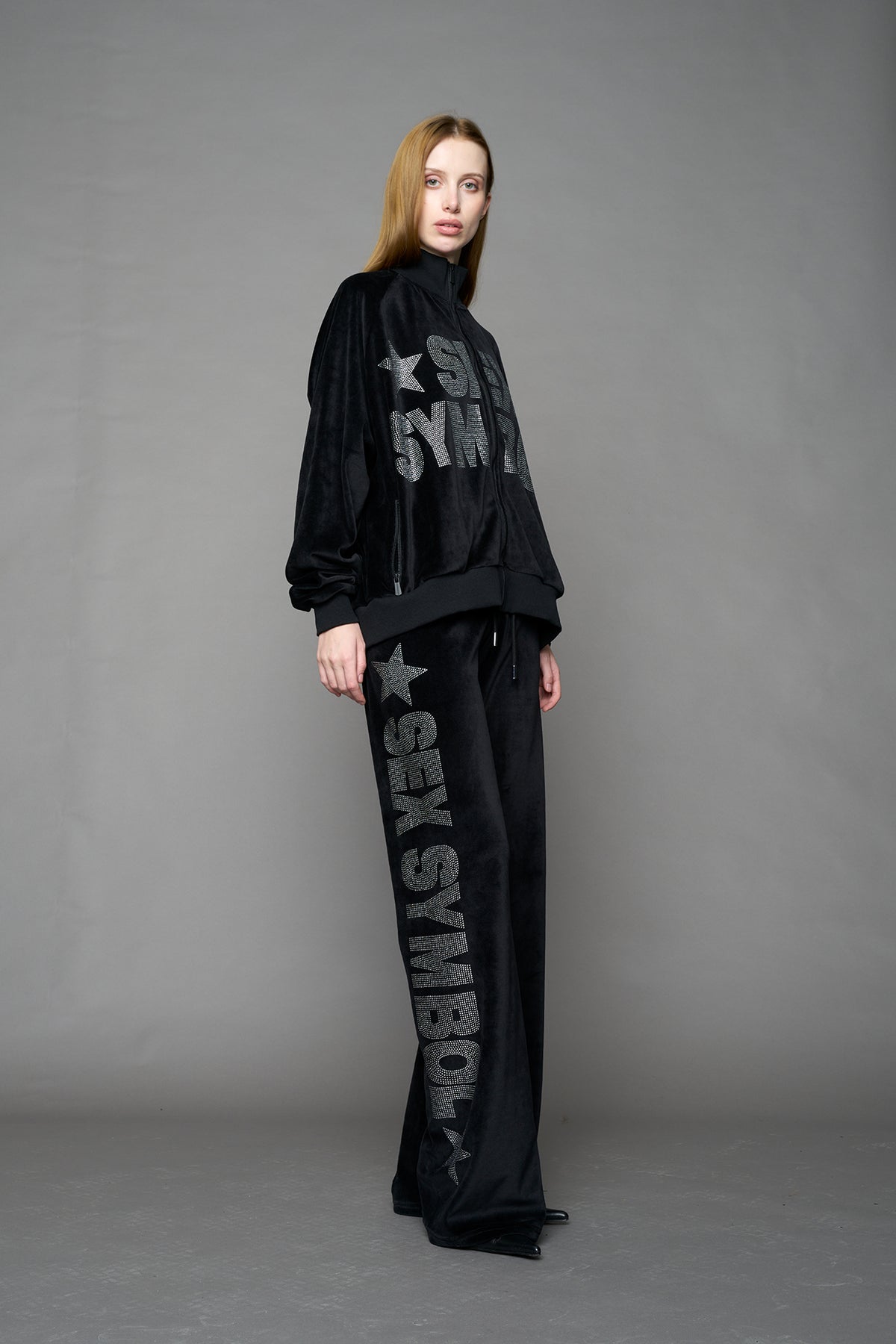 Black velour pants with NAMILIA x Symbol rhinestone detailing and a fitted straight-leg silhouette