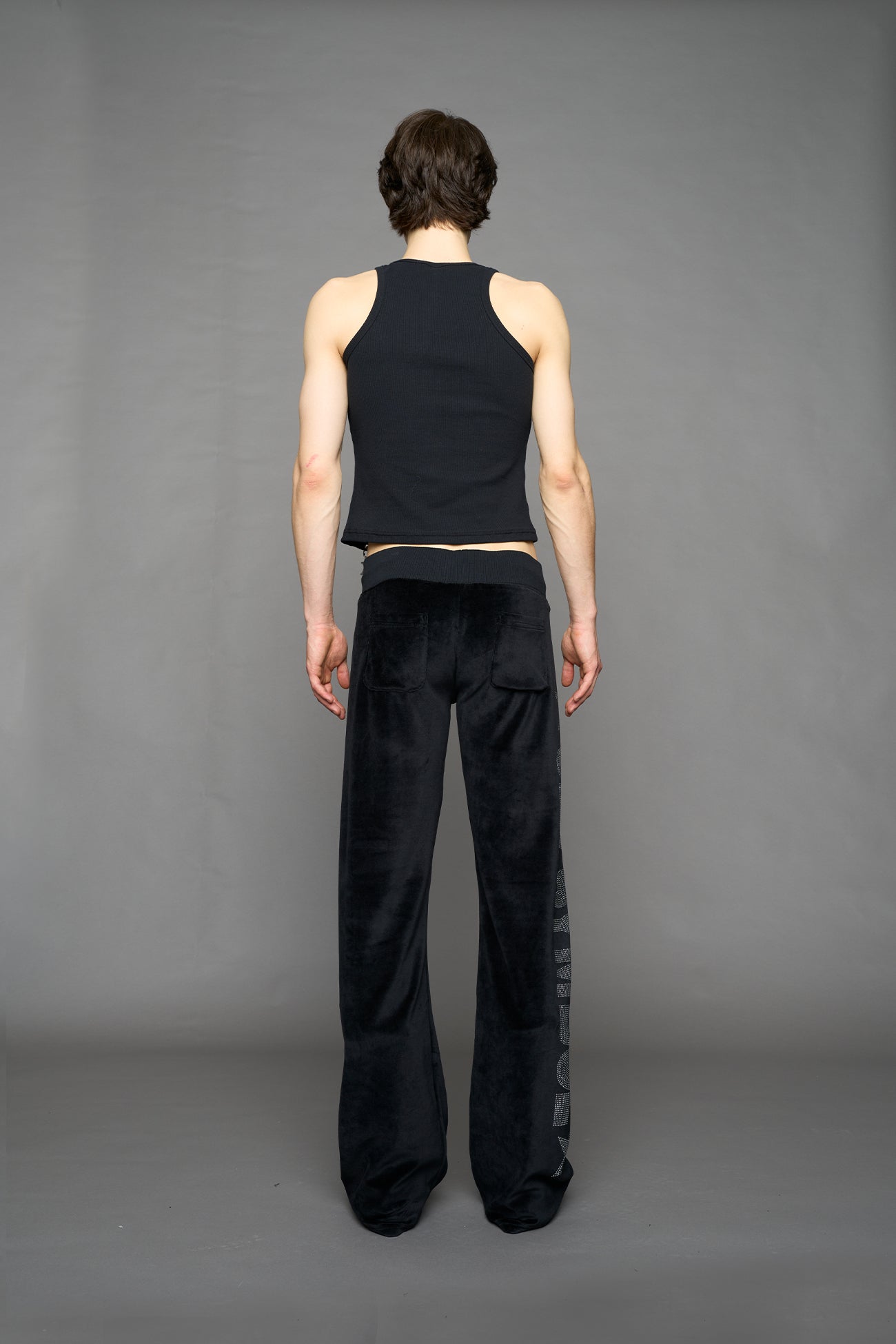 Black velour pants with NAMILIA x Symbol rhinestone detailing and a fitted straight-leg silhouette