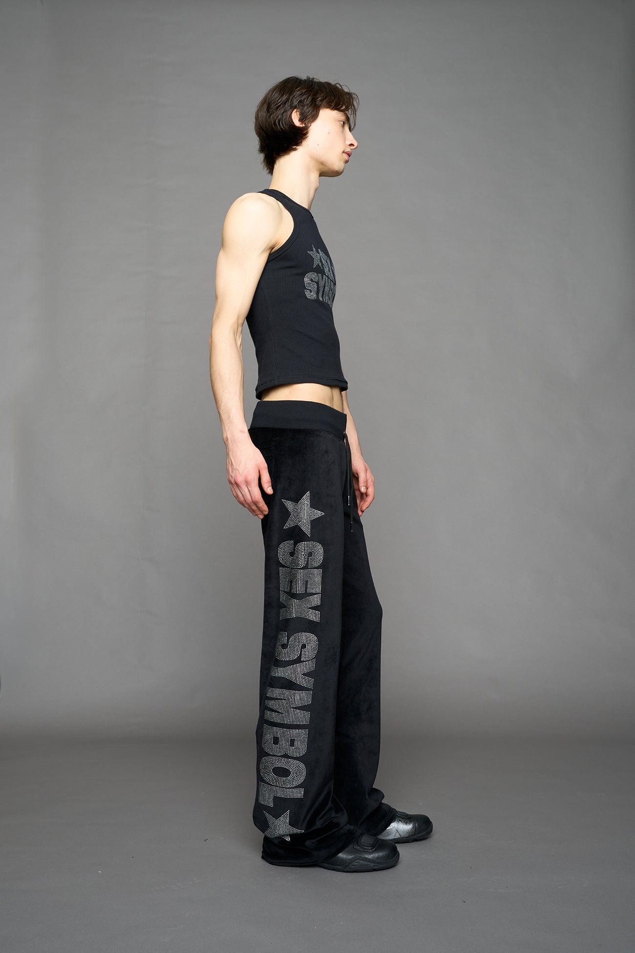 Black velour pants with NAMILIA x Symbol rhinestone detailing and a fitted straight-leg silhouette