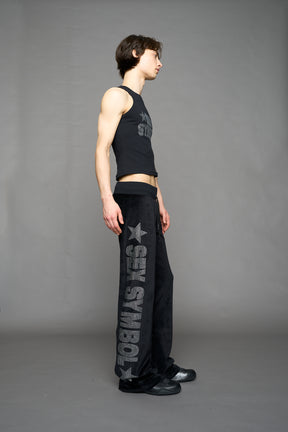 Black velour pants with NAMILIA x Symbol rhinestone detailing and a fitted straight-leg silhouette