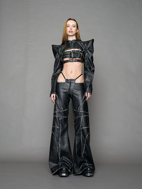 Person wearing a black thong pants with wide-legs and a jacket on a gray background