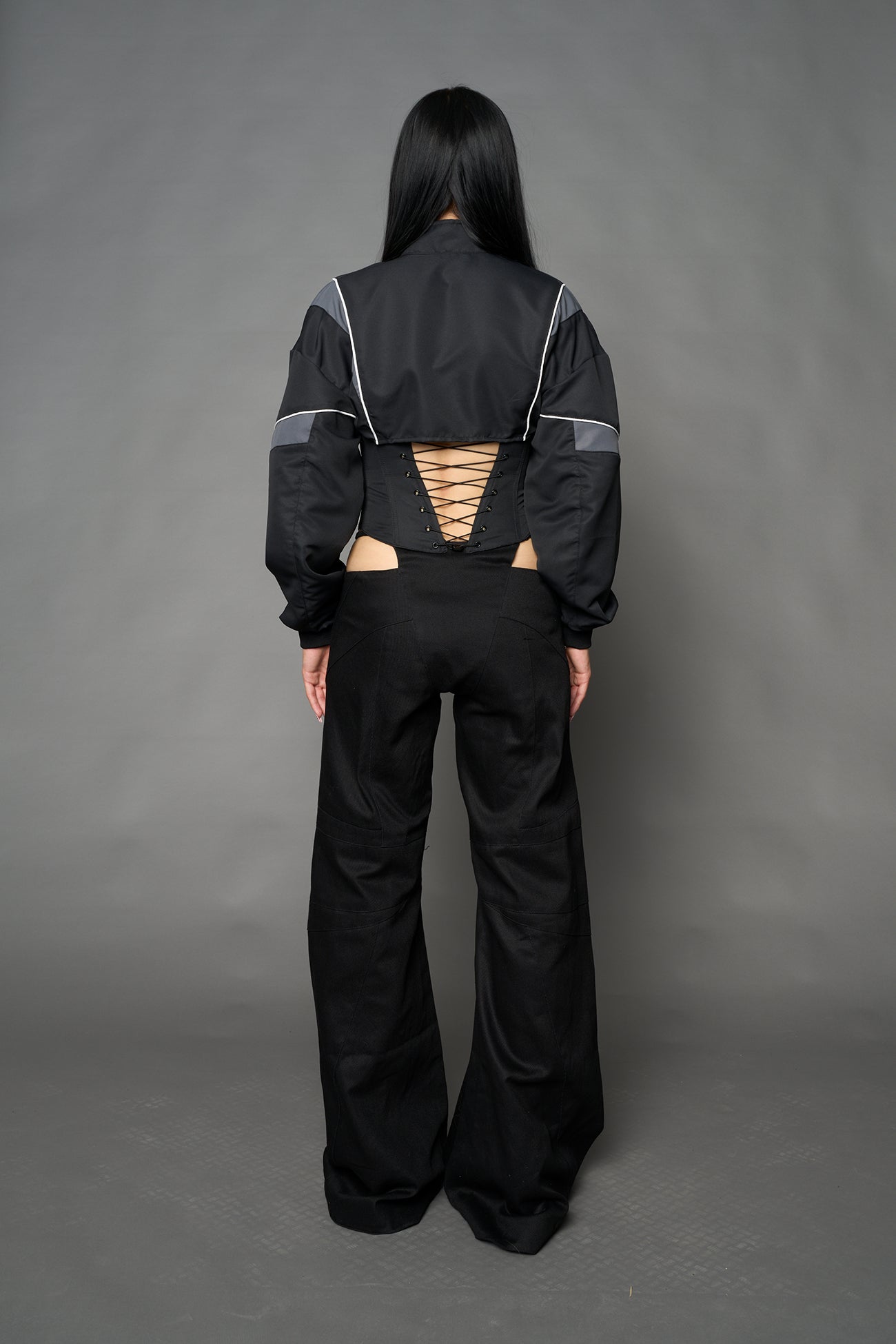 Black Namilia tracksuit jacket with grey sleeve stripes and lace-up corset back