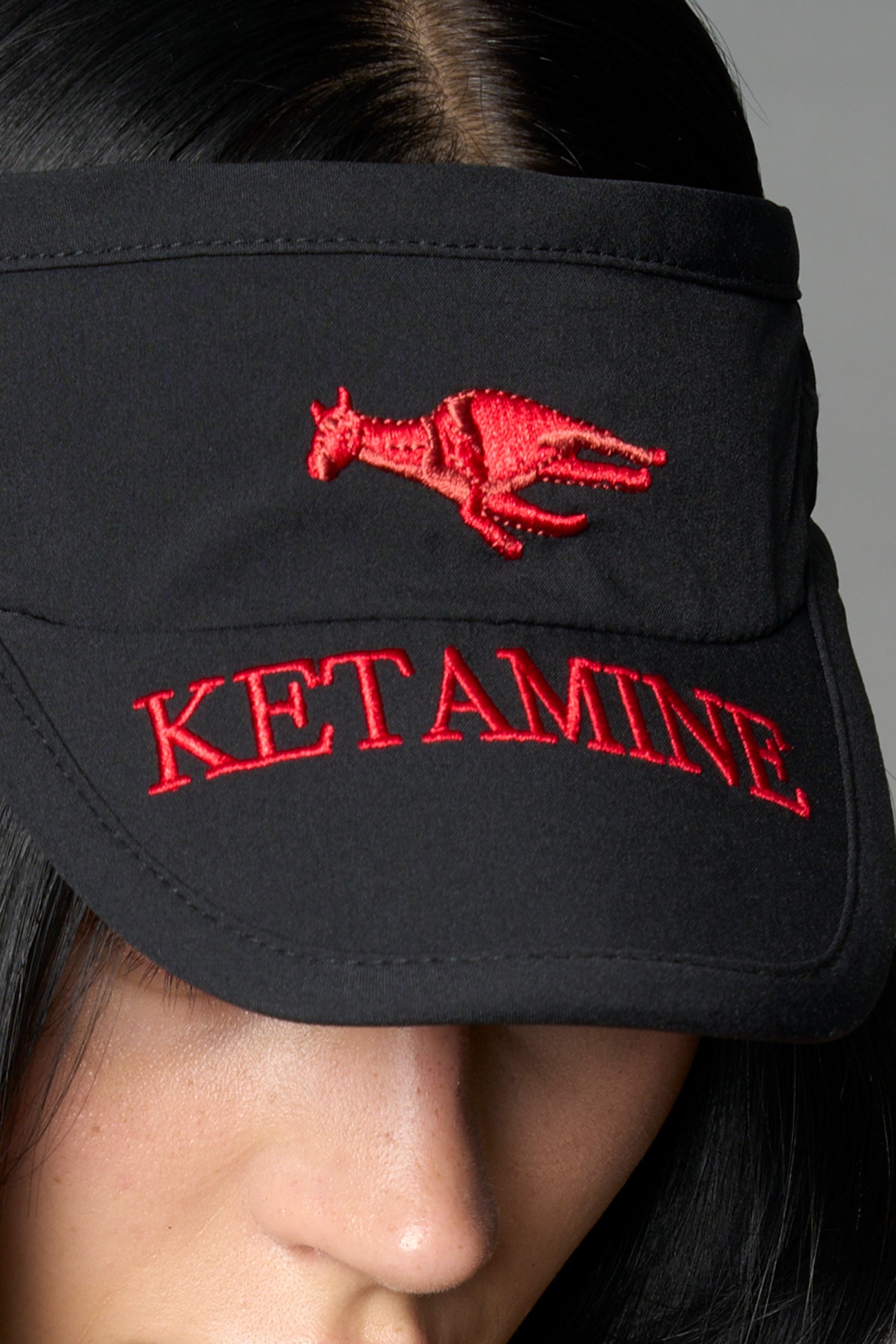Black Namilia visor hat with embroidered horse and bold lettering on brim, unisex streetwear accessory