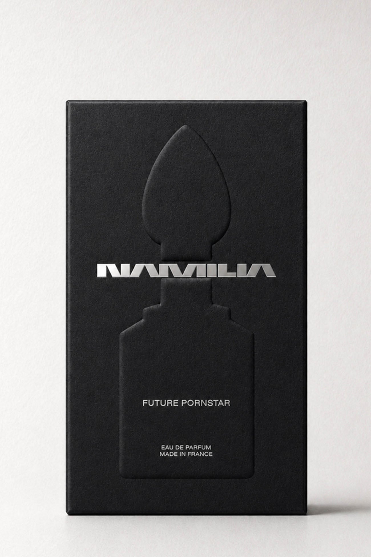 Namilia perfume bottles with metallic silver shaped caps and clear glass bases, filled with pale yellow liquid