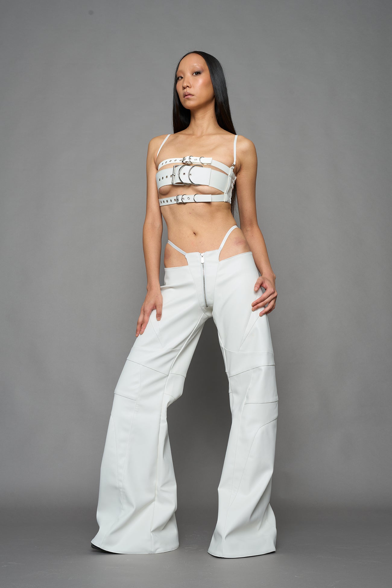 two models wearing white vegan leather pants with thong detail