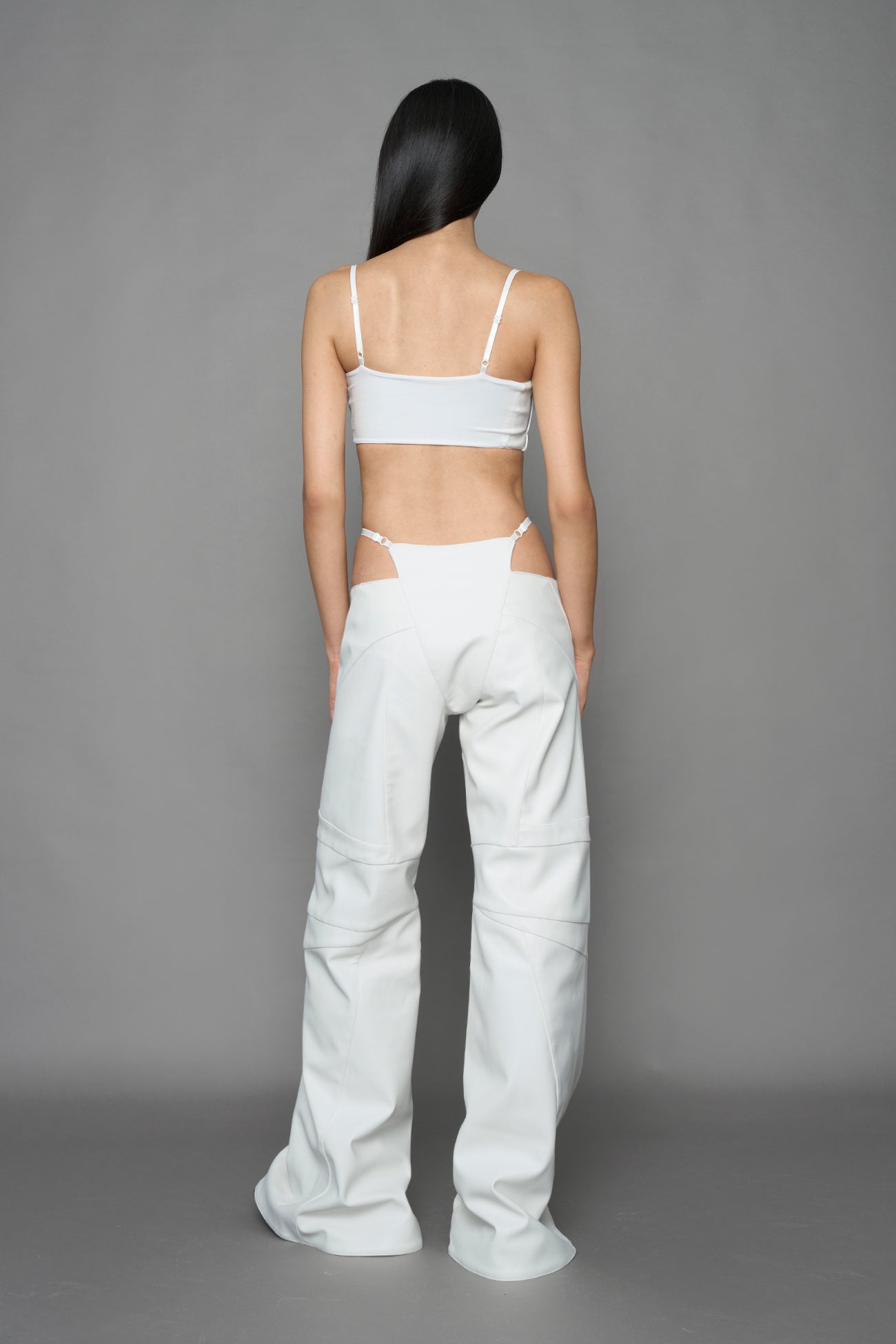 model wearing white vegan leather belt top with buckle details