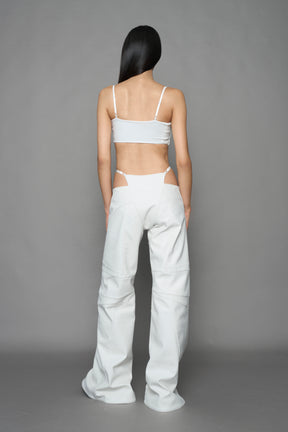 model wearing white vegan leather belt top with buckle details