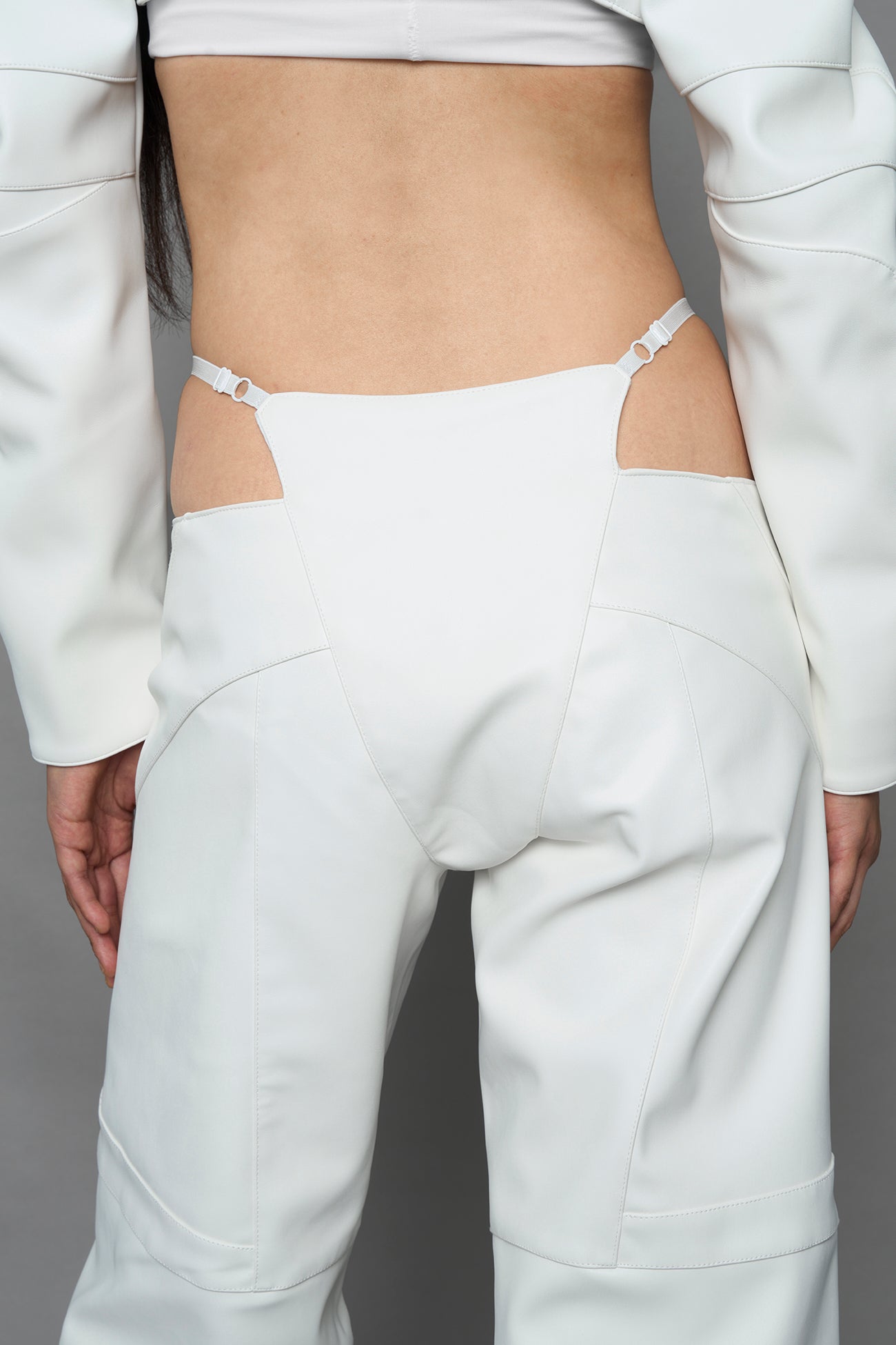 two models wearing white vegan leather pants with thong detail