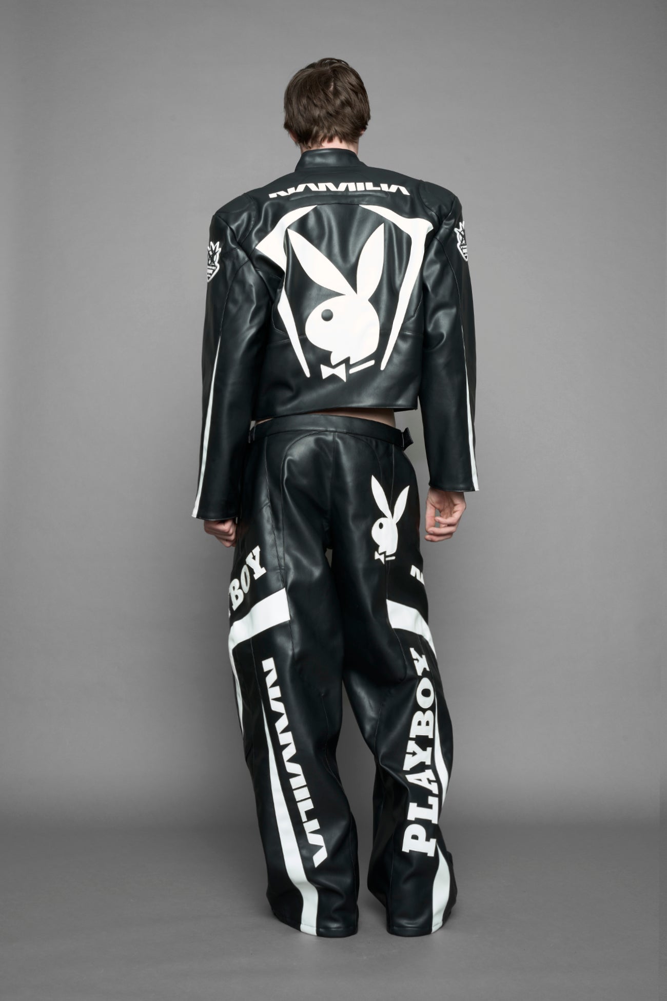 model is wearing black PU Leather pants with bold white Playboy bunny logos and white 'Namilia' Embroidery.