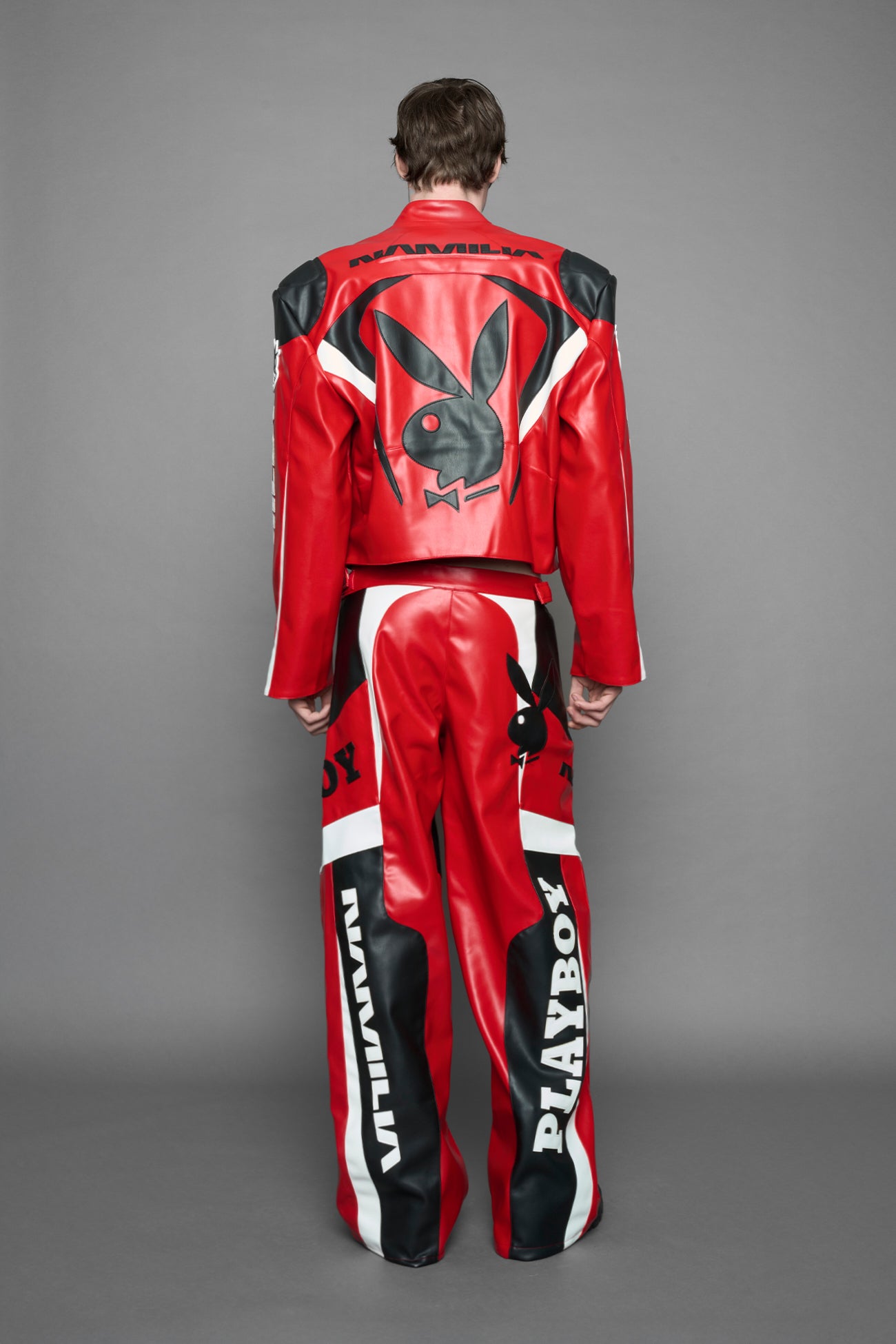 model is wearing red PU Leather pants with bold white Playboy bunny logos and white 'Namilia' Embroidery and rubber tag.