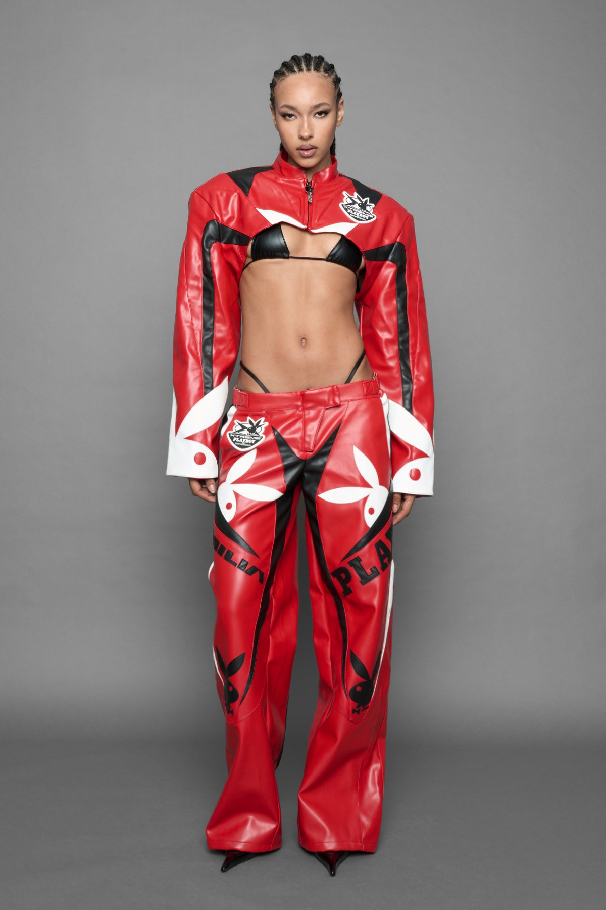 model is wearing red PU Leather pants with bold white Playboy bunny logos and white 'Namilia' Embroidery and rubber tag.