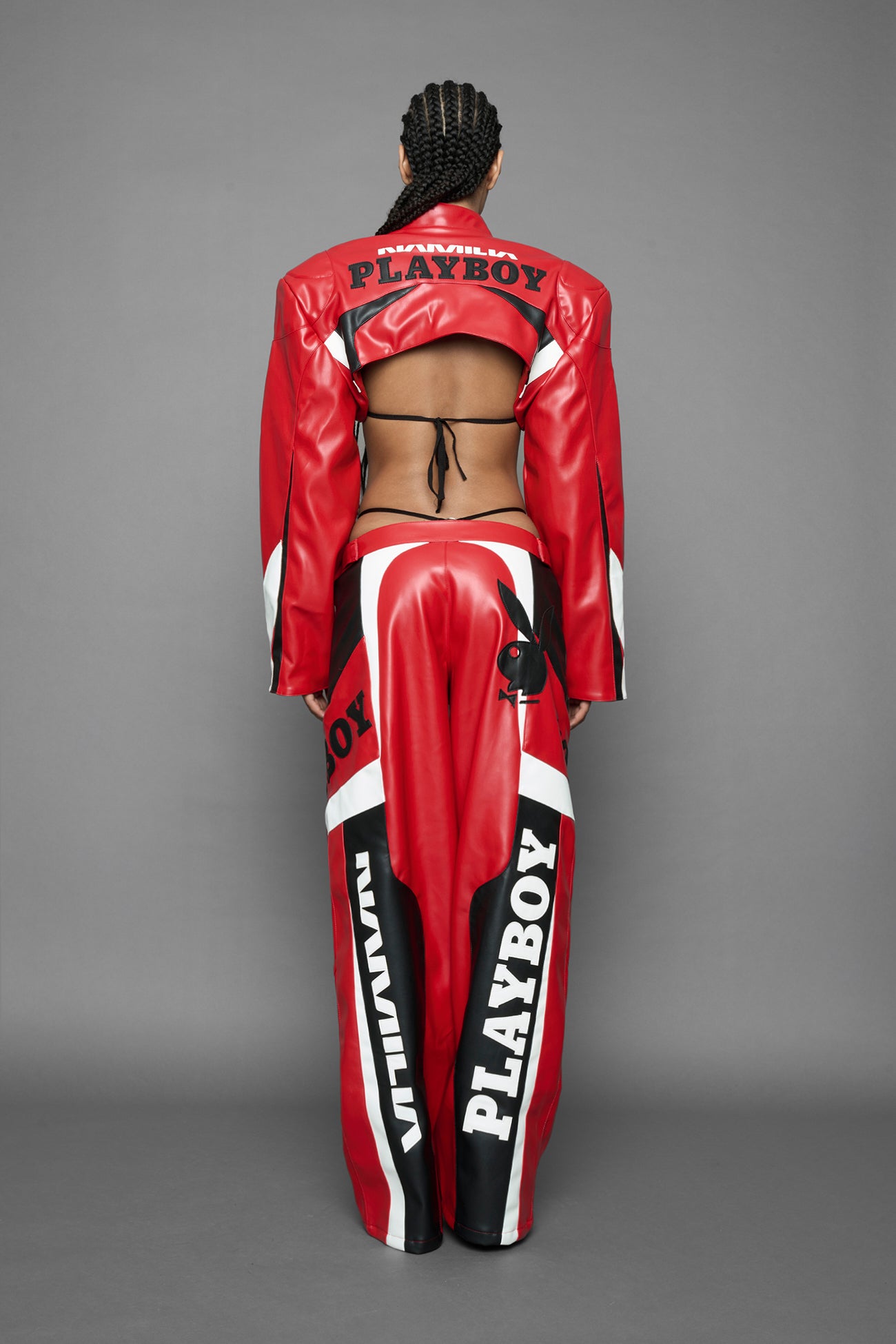 model is wearing red PU Leather pants with bold white Playboy bunny logos and white 'Namilia' Embroidery and rubber tag.