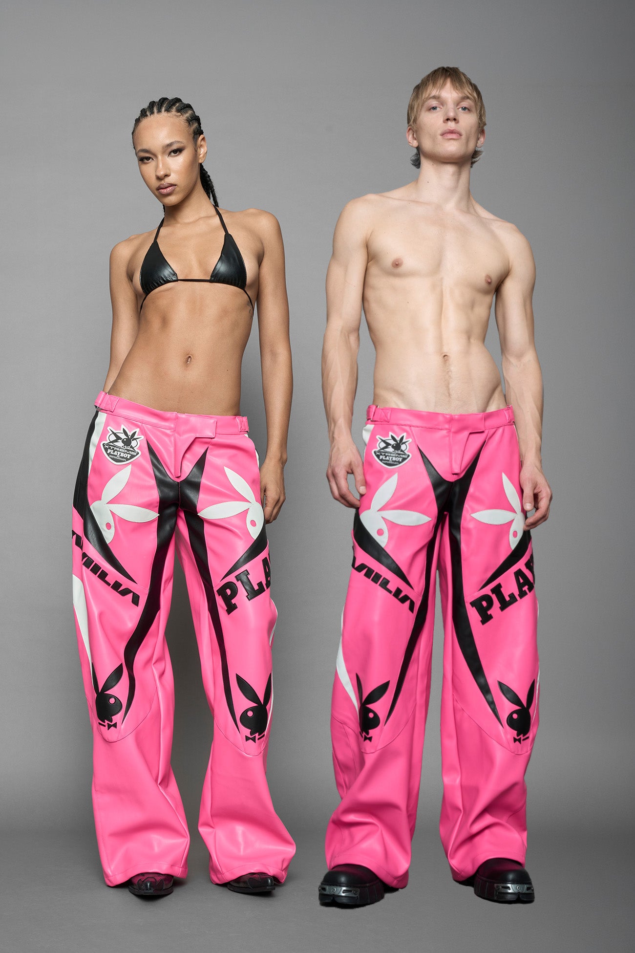 model is wearing pink PU Leather pants with bold white Playboy bunny logos and white 'Namilia' Embroidery and rubber tag.