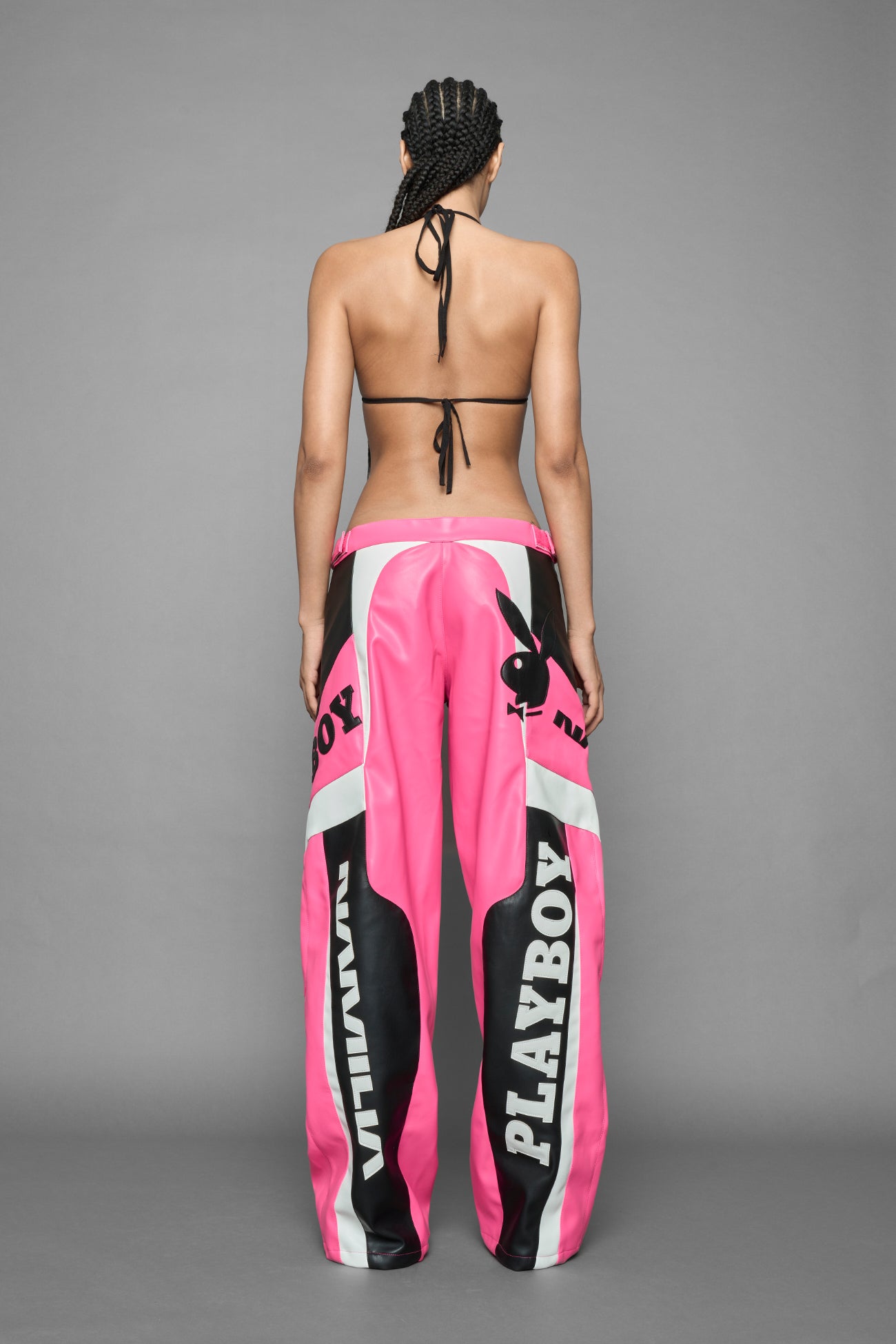 model is wearing pink PU Leather pants with bold white Playboy bunny logos and white 'Namilia' Embroidery and rubber tag.