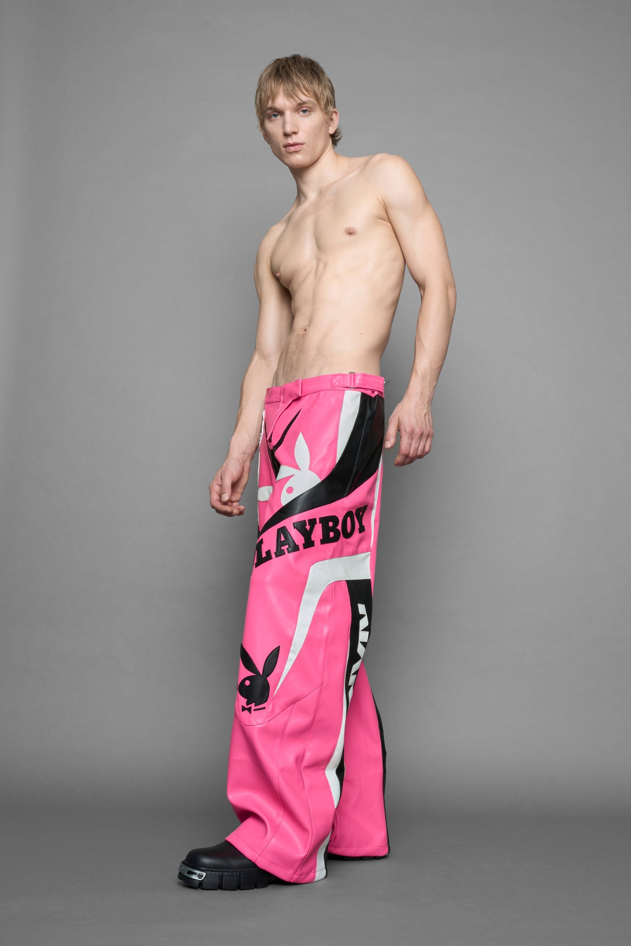 model is wearing pink PU Leather pants with bold white Playboy bunny logos and white 'Namilia' Embroidery and rubber tag.
