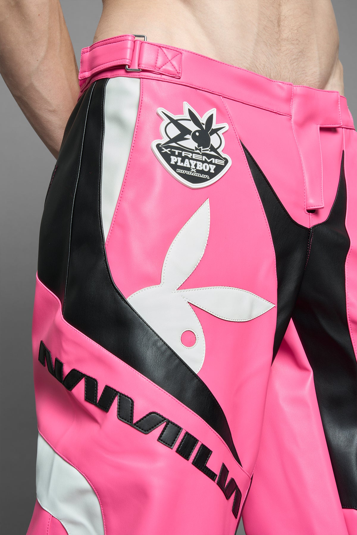 model is wearing pink PU Leather pants with bold white Playboy bunny logos and white 'Namilia' Embroidery and rubber tag.
