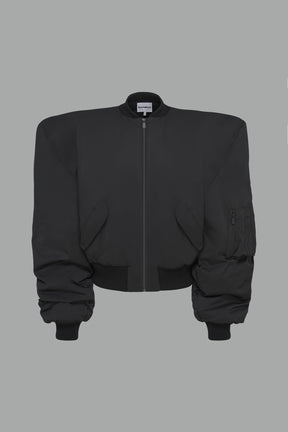 black oversize cropped nylon bomber with exaggerated shoulderpads and ruching on sleeves.
