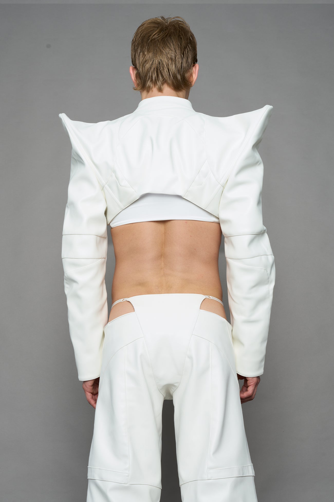 model wearing white vegan leather bolero jacket with spiked shoulder details