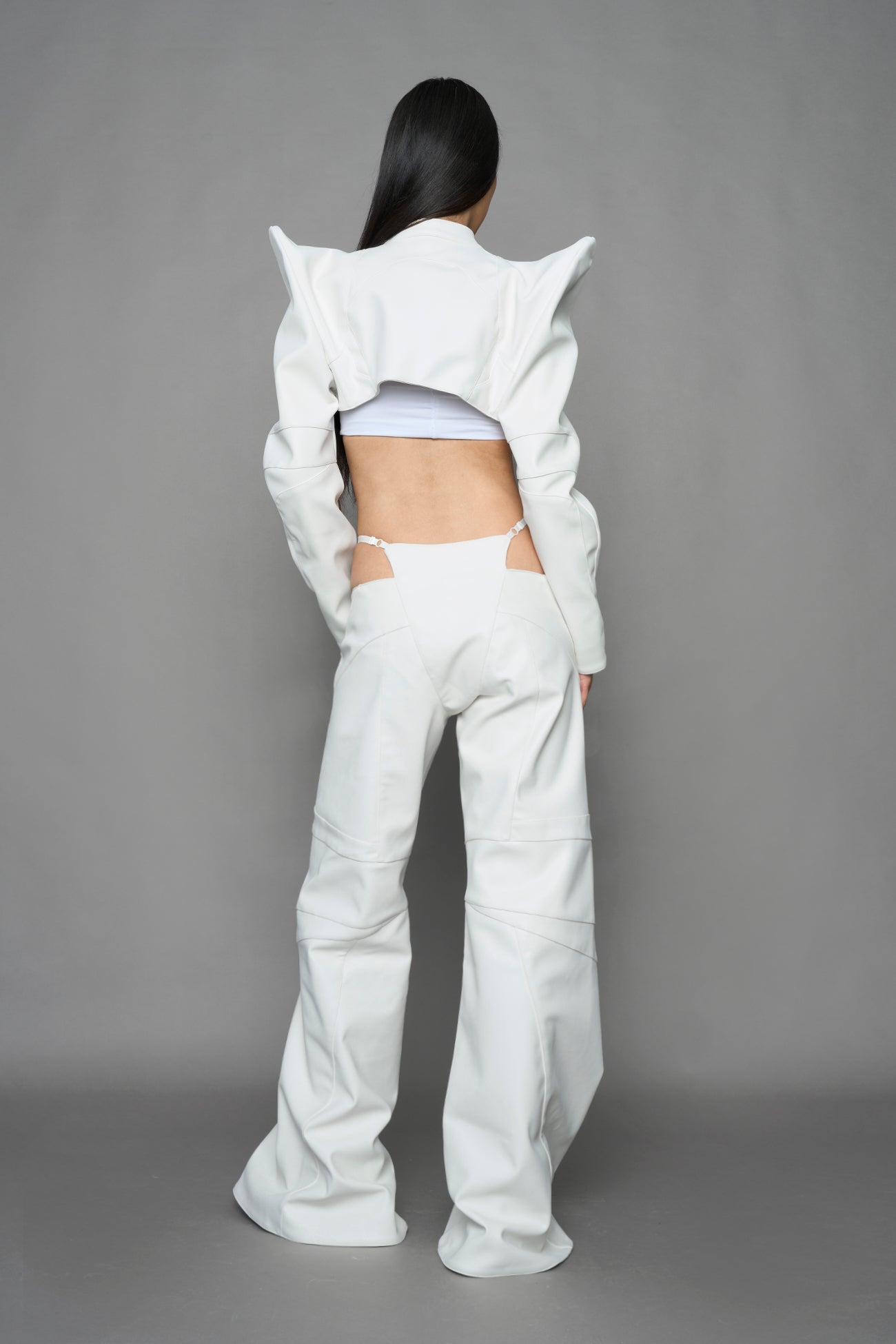 model wearing white vegan leather bolero jacket with spiked shoulder details