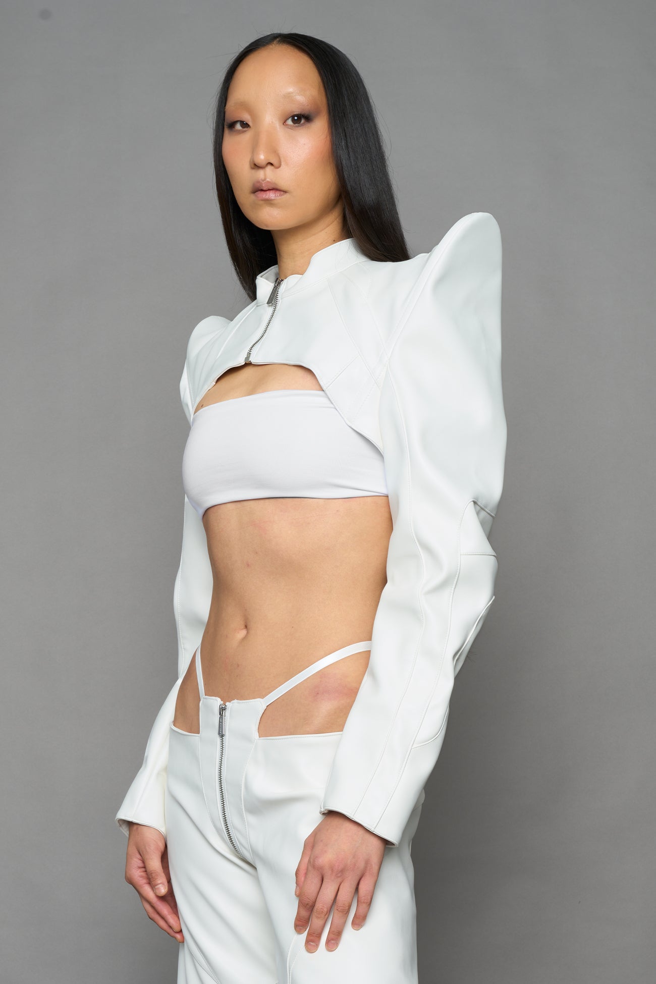 model wearing white vegan leather bolero jacket with spiked shoulder details